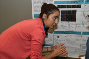 A woman presenting some of the finer points of the poster she has submitted.