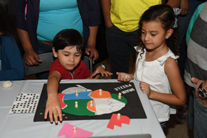 two small children playing with a brain puzzle 