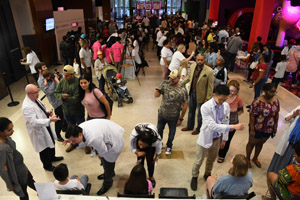 A long shot of the exhibit hall showing a large gathering and many exhibits