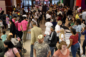 a long shot of the exhibition hall that shows multiple people and exhibits