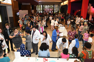 a long shot of the exhibition hall that shows multiple people and exhibits