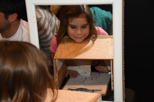 A female child doing an experiment of drawing an image without looking at her hands