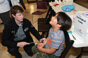 child laughing while having his reflexes tested 