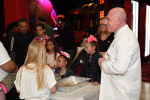 Several people in a crowd observing a lecture or experiment