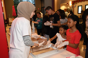 A woman in a habib helping a teenager pick up a human brain