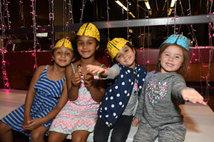 four children wearing brain hats hamming it up for the camera