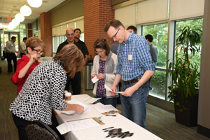 Several people looking at papers on a table in the hallway