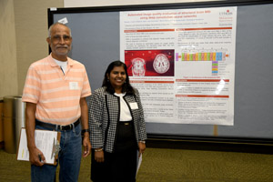 Two people with clipboards standing in front of a poster
