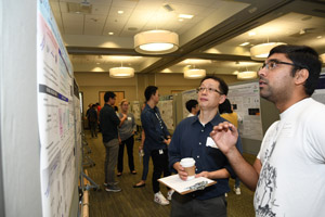 Two men discussing a poster