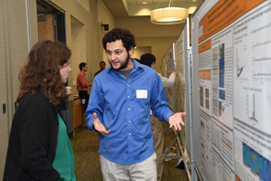 A man explaining his poster to a female