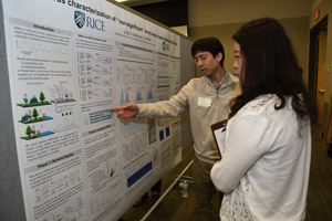 A man explaining his poster to a female