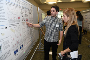 A man explaining his poster to a female