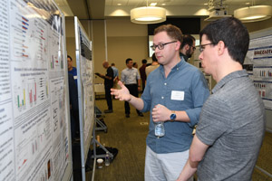 Two men discussing a poster.