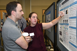 A woman and a man having a discussion about one of the posters