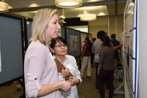 Two women discussing a poster