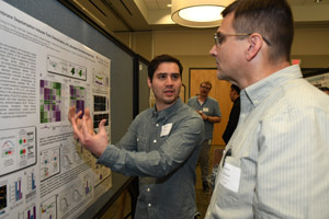 Two men discussing a poster