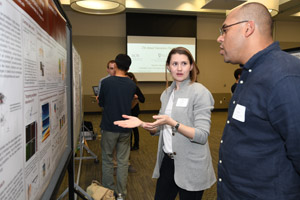 A woman explaining her poster to a man