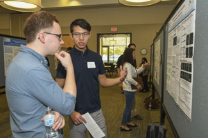Two young men discussing a presenation poster