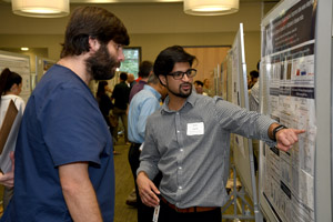 Two men discussing a poster.