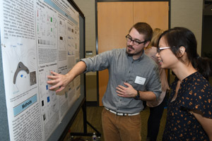 A man and a woman discussing a presenation poster