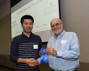 A man presenting a blue winner's ribbon to a male
