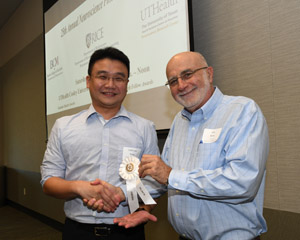 A man presenting a white winner's ribbon to a male