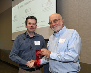 A man being presented a red ribbon