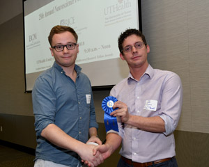 A man being presented a blue ribbon