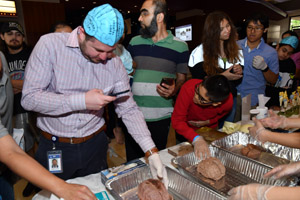 a man with a blue brain hat on touching a preserved human brain
