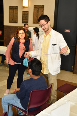 A woman watching a child being experimented on by a man wear a lab coat