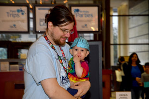 A man holding a small child who is wearing a brain cap