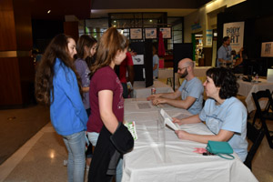 Two teenagers standing at a table getting directions