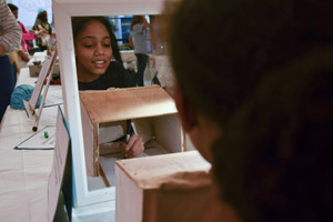 A young girl concentrating very hard drawing an image with seeing what she is drawing