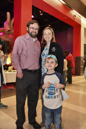 A family unit smiling broadly for posed picture